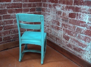 Bhild's blue chair in the corner facing old red brick walls